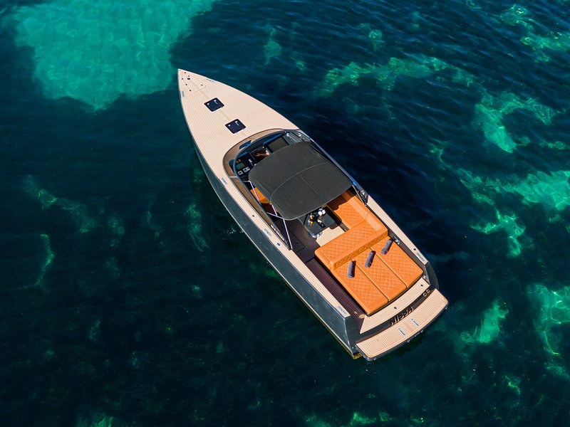 A motorboat over clear water and dark seagrass, seen from above