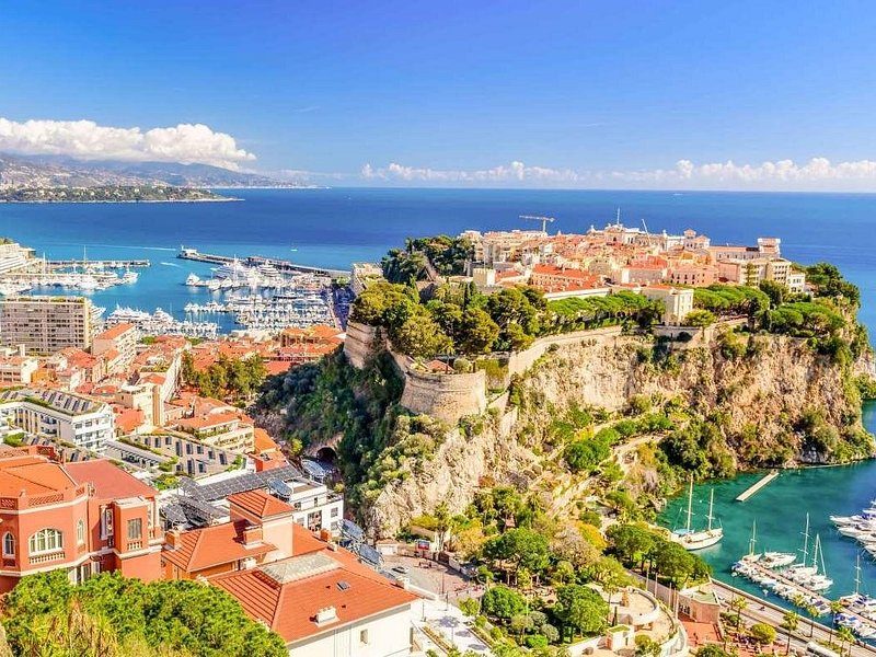 An old town on a rock above the sea, a yacht harbour at its foot