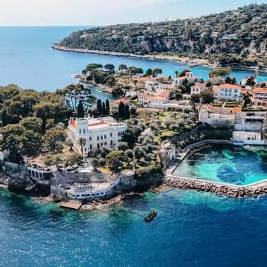 A villa above a natural rock pool on the tip of a green cape